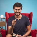 dhruv rathee smiling and holding a pen